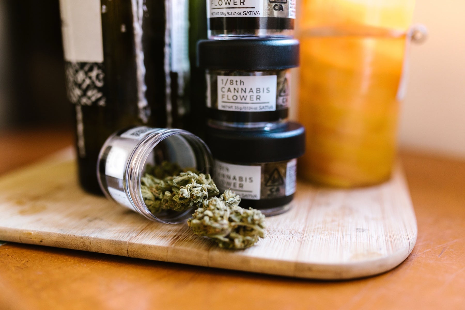 Several small glass jars of cannabis flower representing a series of smaller orders
