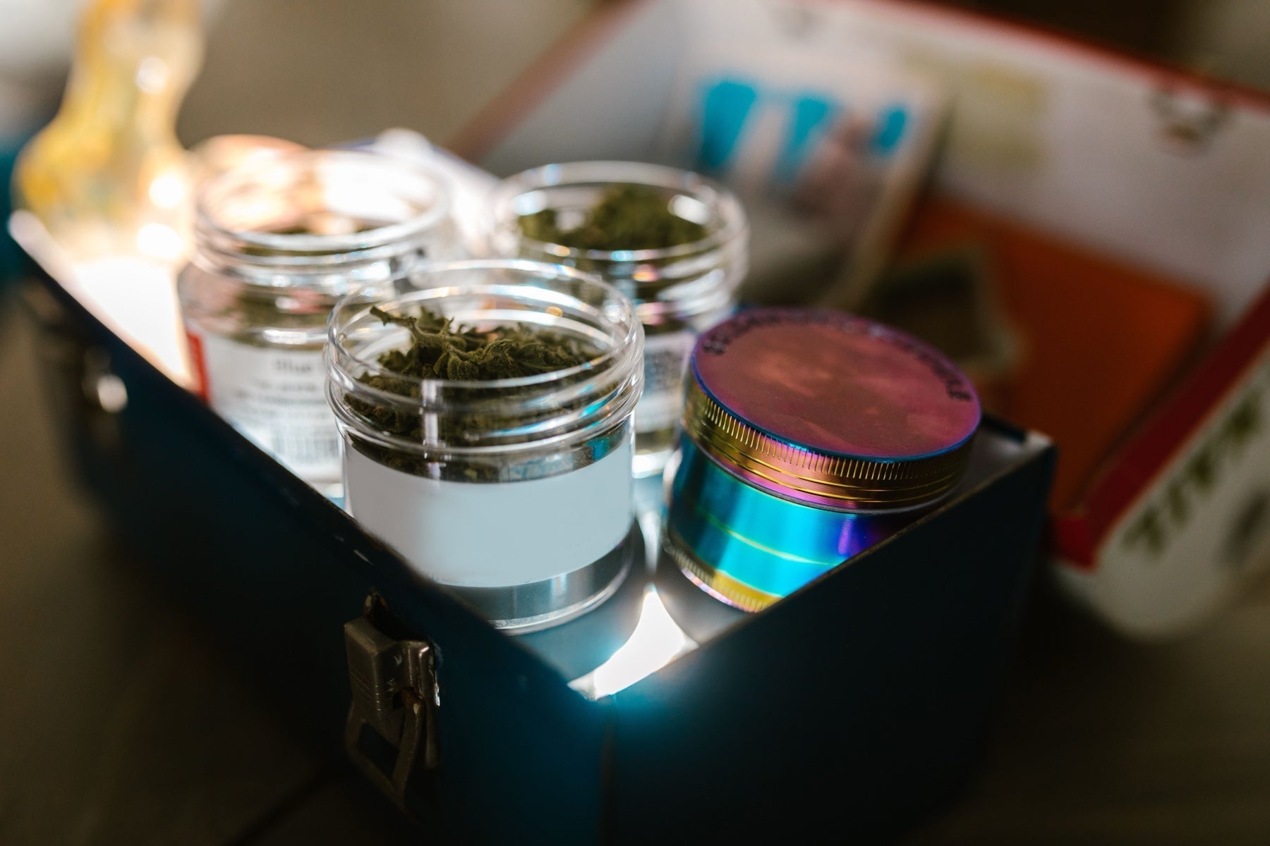 Labeled cannabis flower jars organized together inside a home storage box
