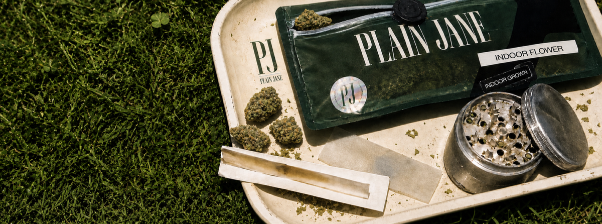 Plain Jane CBD flower pack and rolling tray on green grass