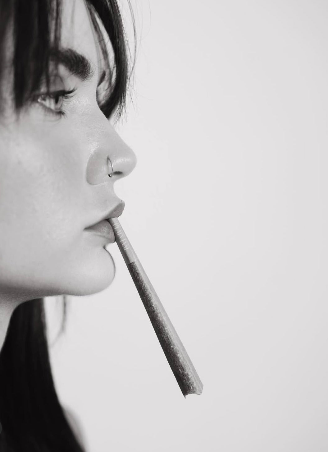 Black-and-white portrait of a woman with a rolled hemp flower product