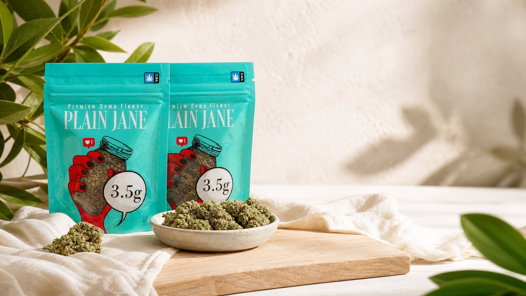 Plain Jane branded hemp flower bags in a warm botanical setting