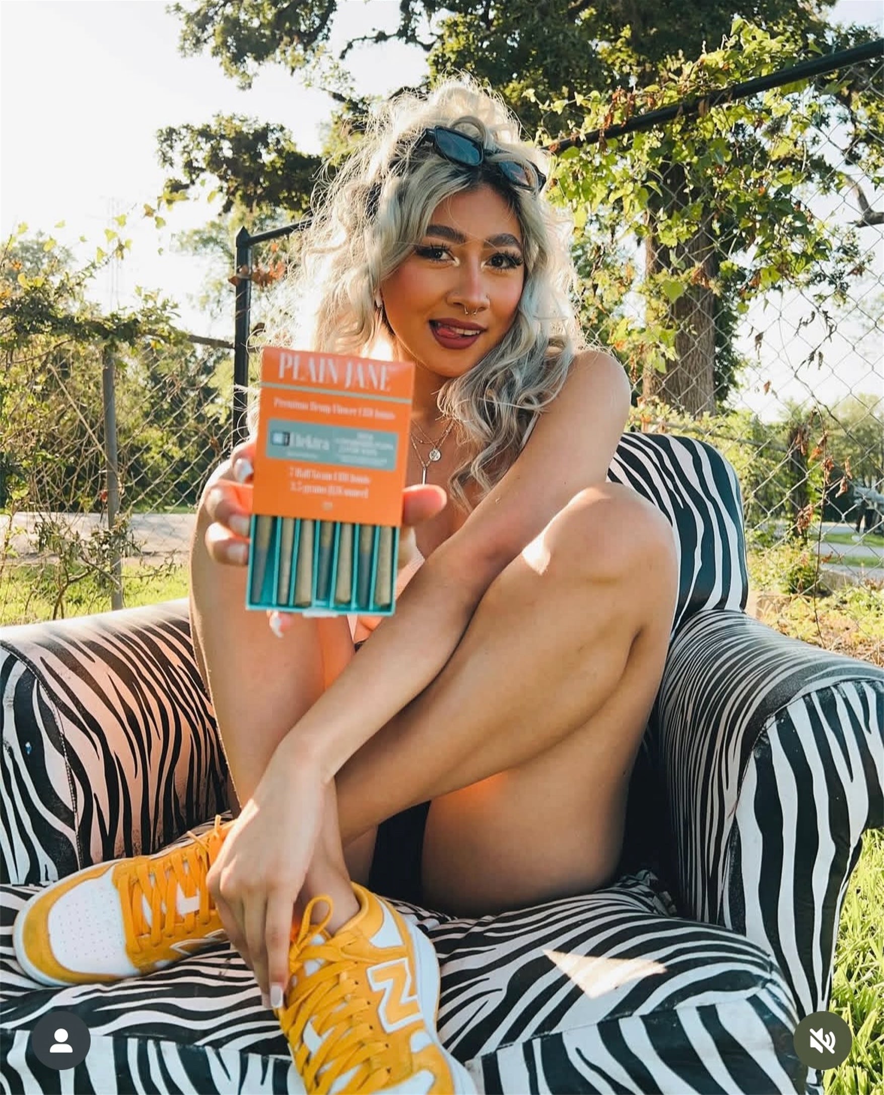 Plain Jane customer holding an orange Plain Jane pre-roll package outdoors