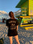 Plain Jane customer wearing a branded shirt at the beach