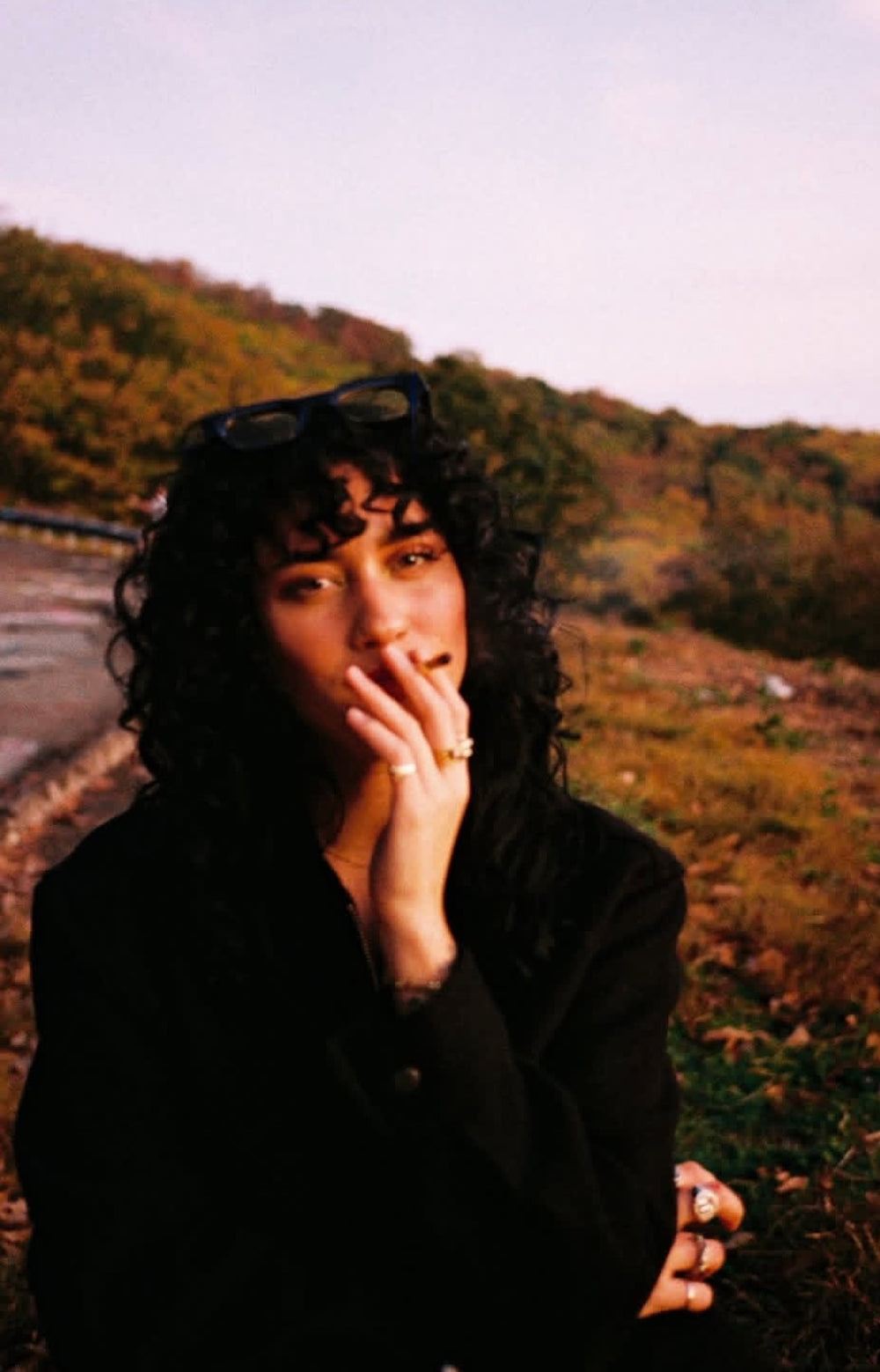 Woman enjoying a hemp roll outdoors in warm golden-hour light