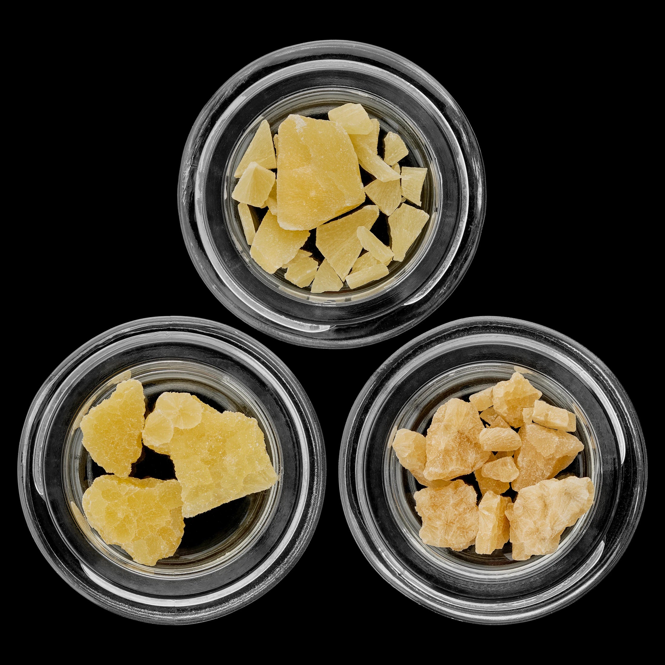 Three glass jars of concentrates in an authentic Plain Jane archive photograph against black